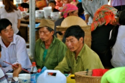 The men drink local corn liquor on market days