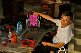 Man paper cutting in his home in Bac Ha
